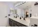 Bathroom featuring dual sinks, modern fixtures, decorative mirror, and light purple paint at 1538 Pony Ranch Cir, Henderson, NV 89014