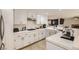 Well-lit kitchen with white cabinets, tile countertops, and modern stainless steel appliances at 1538 Pony Ranch Cir, Henderson, NV 89014
