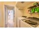 Functional laundry area equipped with a modern washer and dryer, as well as useful shelving at 1538 Pony Ranch Cir, Henderson, NV 89014