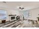 Comfortable living area with a brick fireplace, wood-look floors, and natural light from windows at 1538 Pony Ranch Cir, Henderson, NV 89014