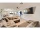 Bright living area with tile flooring, a large sectional couch, and open access to the kitchen at 1538 Pony Ranch Cir, Henderson, NV 89014