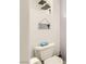 Close up of a toilet with a shelf featuring bathroom-themed decor at 1538 Pony Ranch Cir, Henderson, NV 89014
