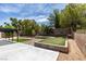 Landscaped backyard featuring artificial turf, mature trees, and a covered patio area at 1673 Golden Vista Dr, Las Vegas, NV 89123