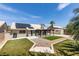 Large backyard featuring artificial grass, a covered patio, pavers, and desert landscaping at 1673 Golden Vista Dr, Las Vegas, NV 89123
