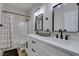 Bright bathroom with double sinks, black hardware, white cabinets, and a shower-tub combo at 1673 Golden Vista Dr, Las Vegas, NV 89123