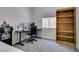 Home office space with gray carpet, a black desk, office chair, and a wood bookcase at 1673 Golden Vista Dr, Las Vegas, NV 89123