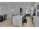 Bright kitchen with white cabinets, eat-in island, and view into dining and living rooms at 1673 Golden Vista Dr, Las Vegas, NV 89123