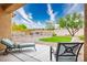 Landscaped backyard featuring low-maintenance gravel, a patch of green grass, and relaxing patio furniture at 1782 Black Fox Canyon Rd, Henderson, NV 89052
