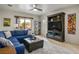 Living room with blue sectional, ceiling fan, and views of the backyard at 1782 Black Fox Canyon Rd, Henderson, NV 89052