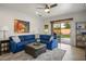 Spacious living room with blue sectional and sliding door access to the patio at 1782 Black Fox Canyon Rd, Henderson, NV 89052