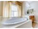 Close up of a soaking tub with a window, and a single vanity at 1963 Dakota Lodge Ave, Las Vegas, NV 89123