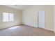 A sunlit bedroom features neutral carpet, a window, and a white door, awaiting personal touches at 1963 Dakota Lodge Ave, Las Vegas, NV 89123