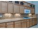 Kitchen featuring granite counters, modern appliances and wood cabinets at 1963 Dakota Lodge Ave, Las Vegas, NV 89123
