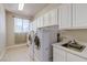 Bright laundry room featuring a sink, white cabinets and newer washer dryer at 1963 Dakota Lodge Ave, Las Vegas, NV 89123