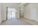 Bright and airy living area with neutral tones, carpet, and sliding glass door access to the backyard at 1963 Dakota Lodge Ave, Las Vegas, NV 89123
