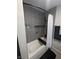 Tiled bathtub and shower area with black hardware, integrated shelf and black and white decor at 212 Orland St # 22, Las Vegas, NV 89107