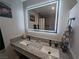 Modern bathroom with double sinks, granite countertops, and a large illuminated mirror at 212 Orland St # 22, Las Vegas, NV 89107