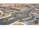 Aerial view of a community entrance with paved streets, center median, palm trees, and desert landscaping at 2213 Chandler Ranch Pl, Laughlin, NV 89029