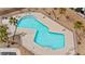 Aerial view of community pool with lounge chairs, restrooms, desert landscaping, and surrounding homes at 2213 Chandler Ranch Pl, Laughlin, NV 89029