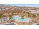 An aerial view of community pool surrounded by desert landscaping and homes with solar panels at 2213 Chandler Ranch Pl, Laughlin, NV 89029