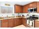 Well-lit kitchen with granite countertops, stainless steel appliances, and ample wooden cabinet space at 2213 Chandler Ranch Pl, Laughlin, NV 89029
