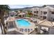 Aerial view of a community pool with cabanas, sun loungers, and a spa against a backdrop of mountains and buildings at 2232 Aspen Mirror Way # 202, Laughlin, NV 89029