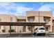 Beige condo building featuring covered parking, landscaped grounds, and clear blue sky at 2232 Aspen Mirror Way # 202, Laughlin, NV 89029