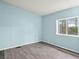 Bright bedroom featuring wood-look flooring, light blue walls, and a window at 240 Navajo Dr, Henderson, NV 89015