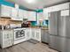Well-lit kitchen featuring white cabinetry, stainless steel appliances, and a neutral-toned backsplash at 240 Navajo Dr, Henderson, NV 89015