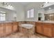 Bright bathroom with a soaking tub, dual sinks, and neutral tile at 2673 Paris Amour St, Henderson, NV 89044