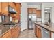Updated kitchen includes granite counters, wood cabinets, stainless steel appliances, and modern fixtures at 2673 Paris Amour St, Henderson, NV 89044