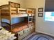 A cozy bedroom features wooden bunkbeds, storage, and a window at 2719 Chinaberry Hill St, Laughlin, NV 89029