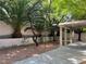 Lush backyard featuring mature landscaping, palm trees, a charming water fountain, and covered patio at 2855 Grande Valley Dr, Las Vegas, NV 89135