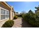 Charming backyard with desert landscaping, stone pathway, mature trees, and neutral stucco exterior at 325 Wild Plum Ln, Las Vegas, NV 89107
