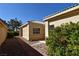Backyard view showcasing the neutral stucco exterior, stone path, desert landscaping, and clear sky above at 325 Wild Plum Ln, Las Vegas, NV 89107