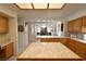 Open kitchen with tile countertops, an island, and natural wood cabinetry at 325 Wild Plum Ln, Las Vegas, NV 89107