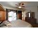 Bright main bedroom featuring hardwood floors, a ceiling fan, and a door leading to the backyard at 325 Wild Plum Ln, Las Vegas, NV 89107