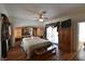 Bright main bedroom featuring hardwood floors, a ceiling fan, and a door leading to the backyard at 325 Wild Plum Ln, Las Vegas, NV 89107