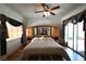 Bright main bedroom featuring hardwood floors, a ceiling fan, and a door leading to the backyard at 325 Wild Plum Ln, Las Vegas, NV 89107