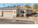Home exterior with a two-car garage, desert landscaping, and tile roof at 3342 Pheasant Canyon Way # 1013, Laughlin, NV 89029