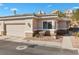 Home exterior with a two-car garage, desert landscaping, and tile roof at 3342 Pheasant Canyon Way # 1013, Laughlin, NV 89029