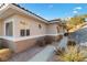 Side exterior of home with desert landscaping, showing stucco walls and a sidewalk leading to the entrance at 3342 Pheasant Canyon Way # 1013, Laughlin, NV 89029