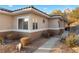Single-story home with rock landscaping, desert plants, and a sidewalk leading to the front door at 3342 Pheasant Canyon Way # 1013, Laughlin, NV 89029