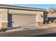 Close-up of a two-car garage with desert-style landscaping at 3342 Pheasant Canyon Way # 1013, Laughlin, NV 89029