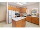 Fully equipped kitchen with island, white appliances, tiled floors, and wood cabinetry at 3342 Pheasant Canyon Way # 1013, Laughlin, NV 89029
