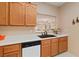 Cozy kitchen featuring wood cabinetry, stainless steel appliances, and pass-through window to the living room at 3342 Pheasant Canyon Way # 1013, Laughlin, NV 89029
