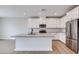 Modern kitchen featuring stainless steel appliances, quartz countertops, and a central island at 3357 Via Tizzoni St, Henderson, NV 89044