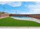 The backyard features a modern swimming pool and artificial turf with a brick perimeter fence at 3556 Valley Lily St, North Las Vegas, NV 89032