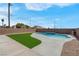 The backyard features a modern swimming pool and artificial turf with a brick perimeter fence at 3556 Valley Lily St, North Las Vegas, NV 89032