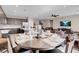 Bright dining area featuring an elegant round table with seating for four, open to the kitchen and living spaces at 3556 Valley Lily St, North Las Vegas, NV 89032